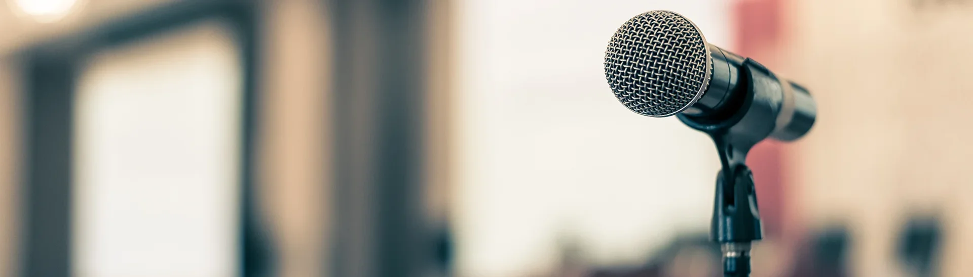 Town hall meeting in an empty room, focused on the microphone.