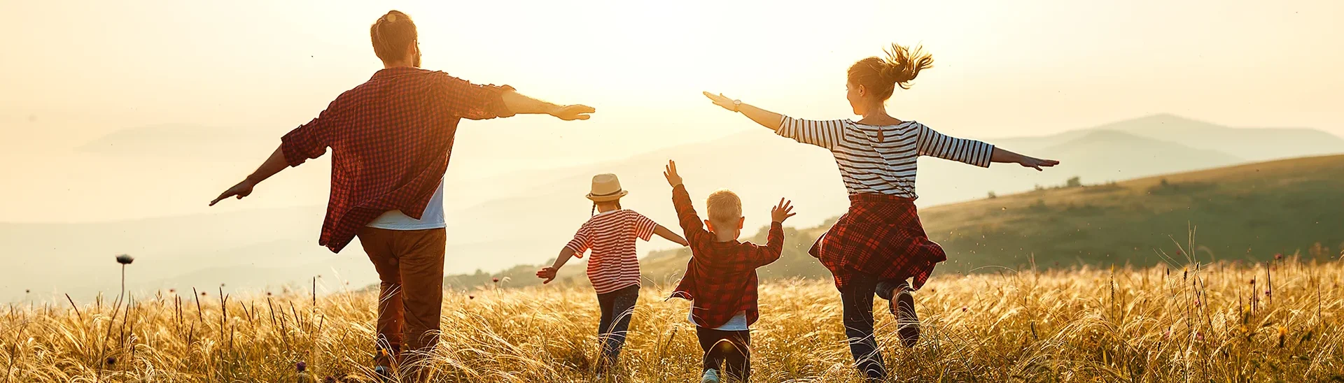 Una familia feliz corriendo por el campo