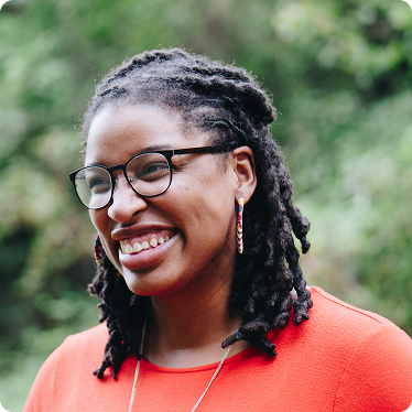 black-woman-smiling-in-orange-shirt Black woman smiling in orange shirt