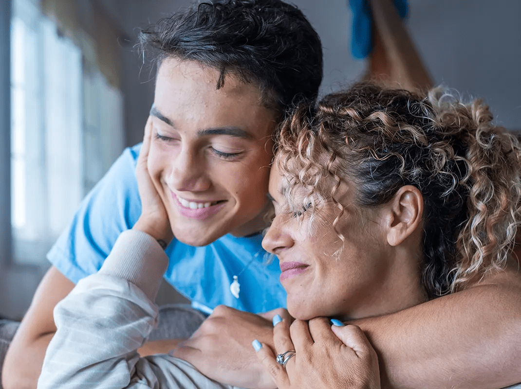 Mom and son hugging and smiling