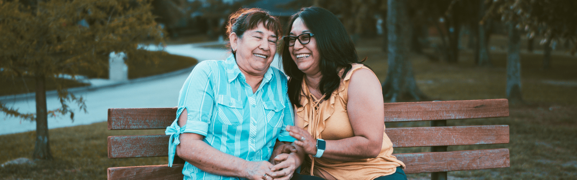 Women sitting on bench laughing