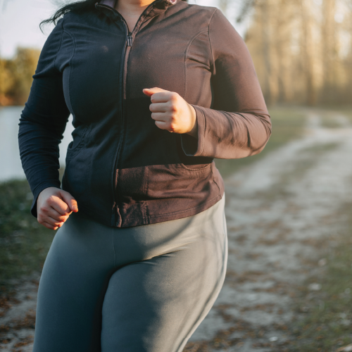 Woman running on a path near a lake.