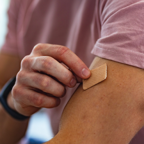 Man putting on a nicotine patch to help quit smoking.