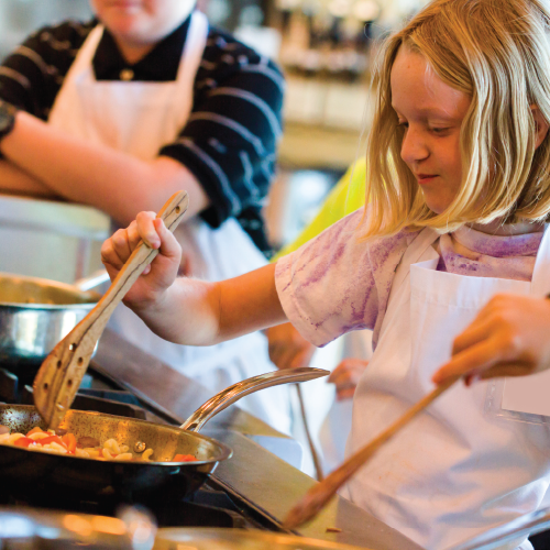 Página principal de WNC Thrive banner de niños aprendiendo a cocinar en la cocina.