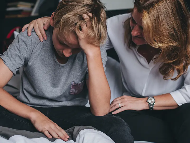 Mom comforting her son who is having a mental health crisis.