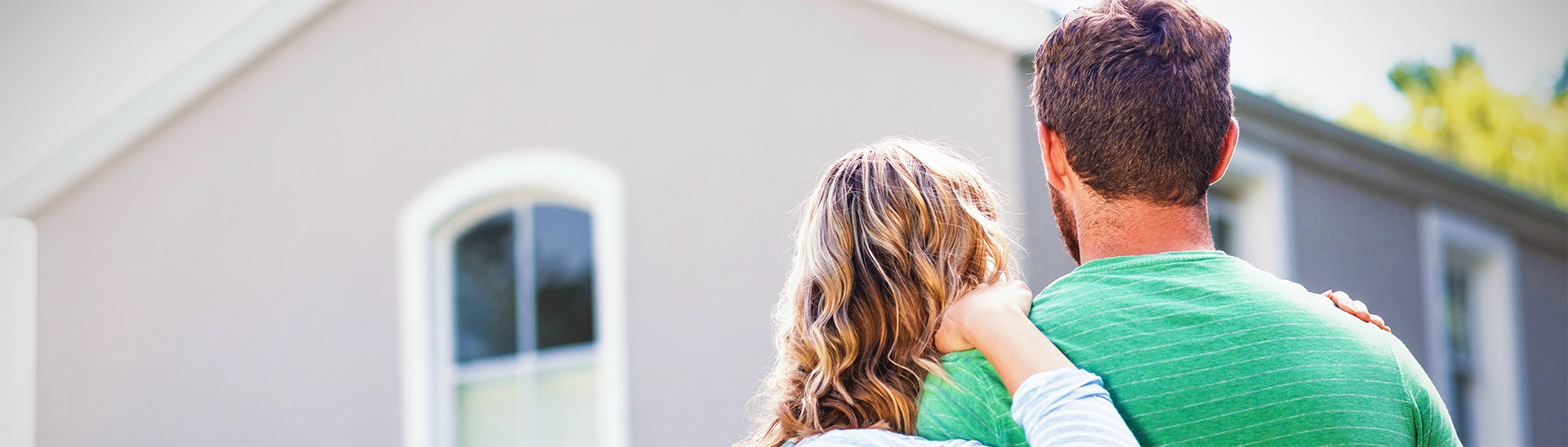 National Radon Testing month with a husband and wife looking at their house from the outside.