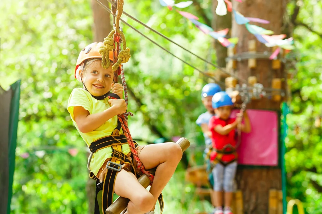 WNC Thrive program image of youth on a ropes course in the woods.