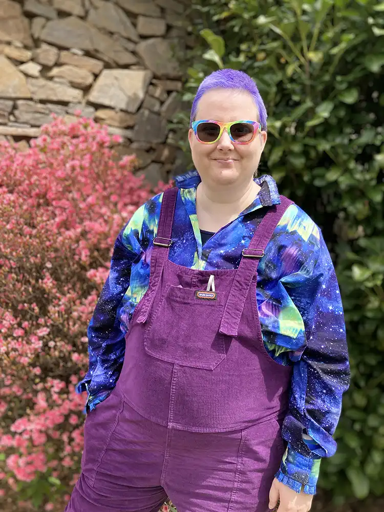 Jade McWilliams in purple overhauls and matching hair color.